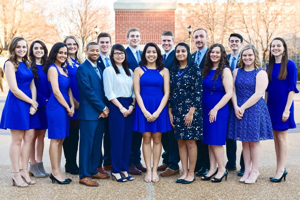 A group of students pose for a photo outside on campus.